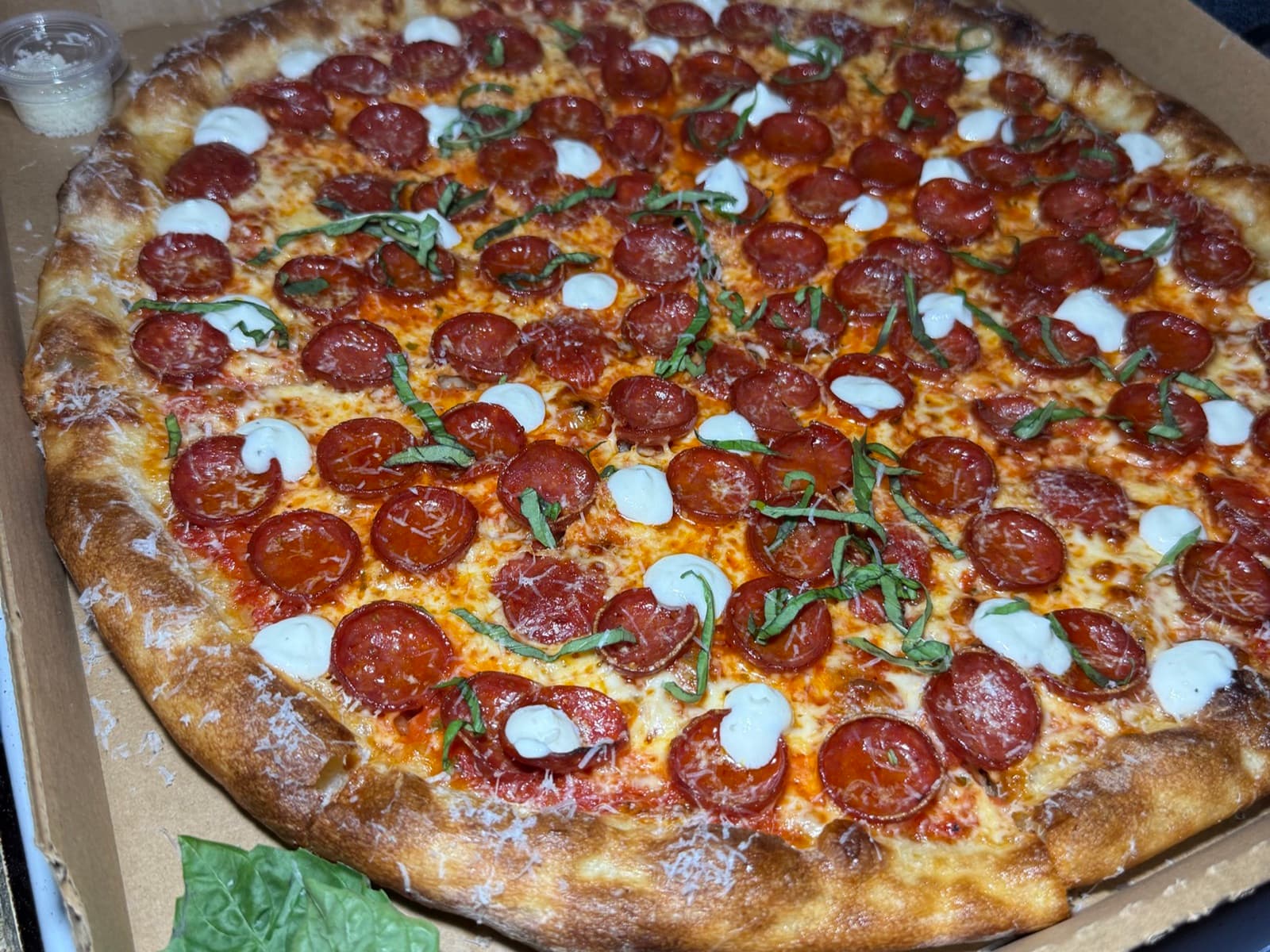 Pepperoni, Ricotta + Basil — a 16-inch thin-and-crispy pie, browned at the crust